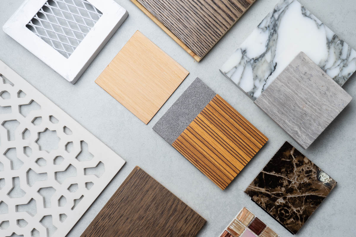 Wood, stone, tile, and metal finish samples arranged on a work surface